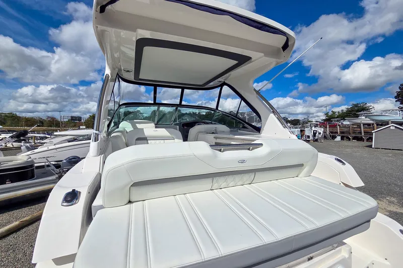  Yacht Photos Pics 2026 Regal 33 XO boat with white seating, docked under a blue sky.