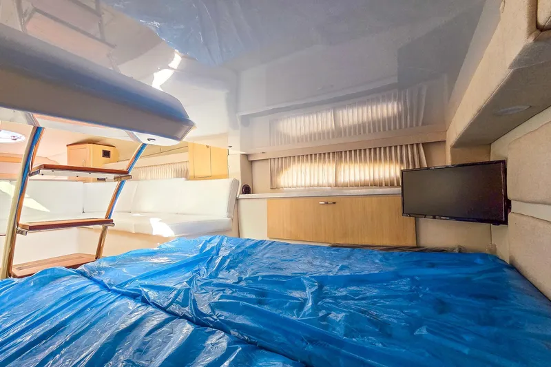  Yacht Photos Pics Interior of 2026 Regal 33 XO yacht with bed, TV, and wooden cabinetry.