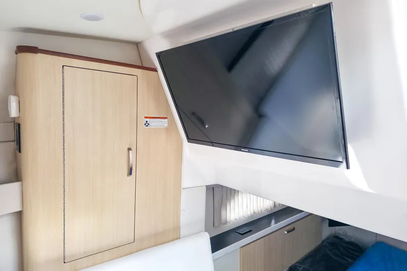  Yacht Photos Pics Interior of 2026 Regal 33 XO boat with mounted TV and wooden cabinet.
