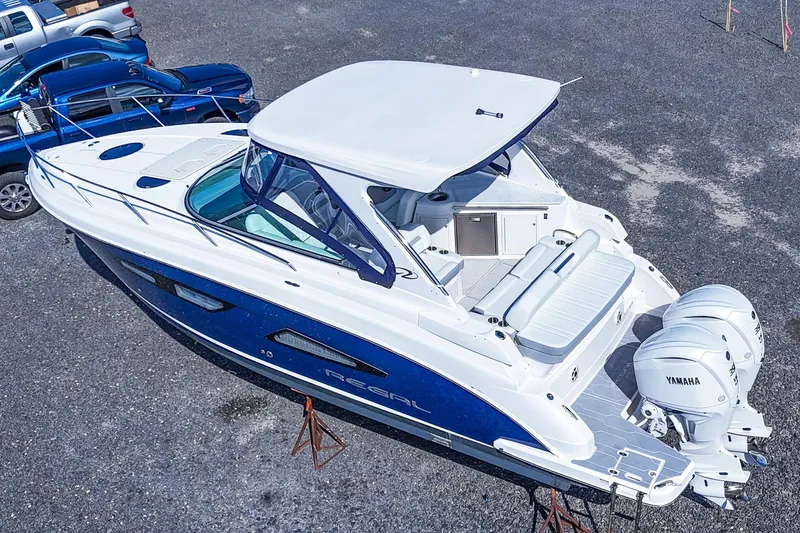  Yacht Photos Pics 2026 Regal 33 XO boat with Yamaha engines, parked on gravel lot.