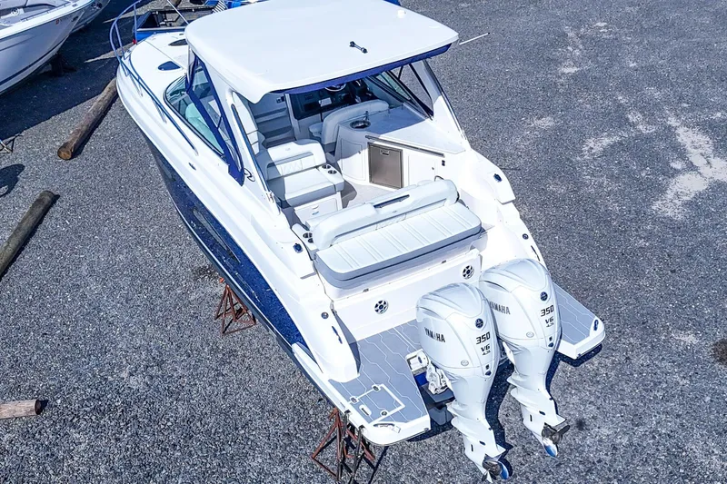  Yacht Photos Pics 2026 Regal 33 XO boat with dual Yamaha 350 engines, parked on gravel.