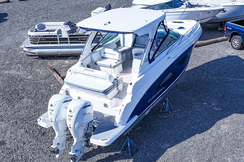  Yacht Photos Pics 2026 Regal 33 XO boat with dual outboard engines, parked on gravel.