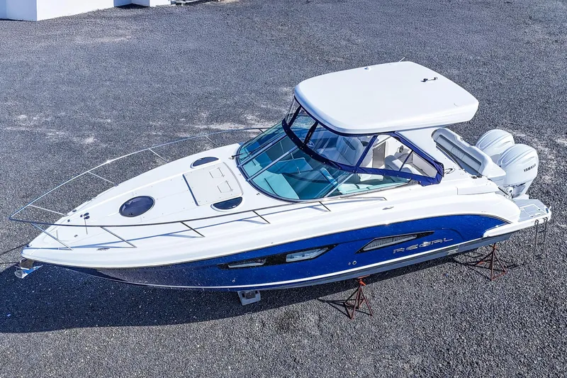  Yacht Photos Pics 2026 Regal 33 XO boat with sleek design, white and blue exterior, on display outdoors.