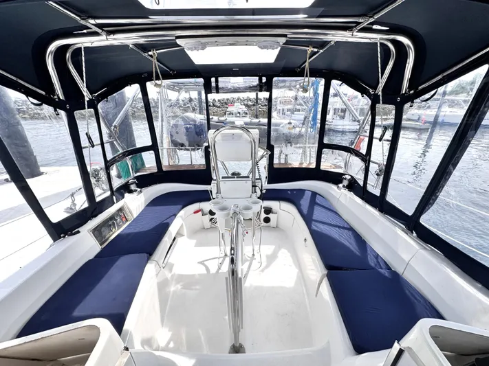 Stormcat Yacht Photos Pics 2006 Hunter 41 Deck Salon cockpit with blue seating, enclosed by clear panels, docked at marina.