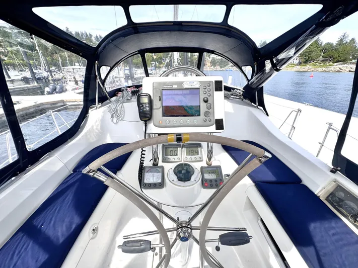 Stormcat Yacht Photos Pics 2006 Hunter 41 Deck Salon cockpit with navigation equipment and steering wheel, docked by the water.