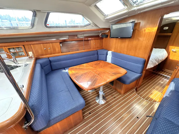 Stormcat Yacht Photos Pics 2006 Hunter 41 Deck Salon interior with blue seating, wooden table, and natural light.