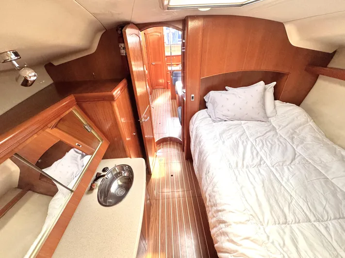 Stormcat Yacht Photos Pics Interior of 2006 Hunter 41 Deck Salon with bed, sink, and wooden cabinetry.