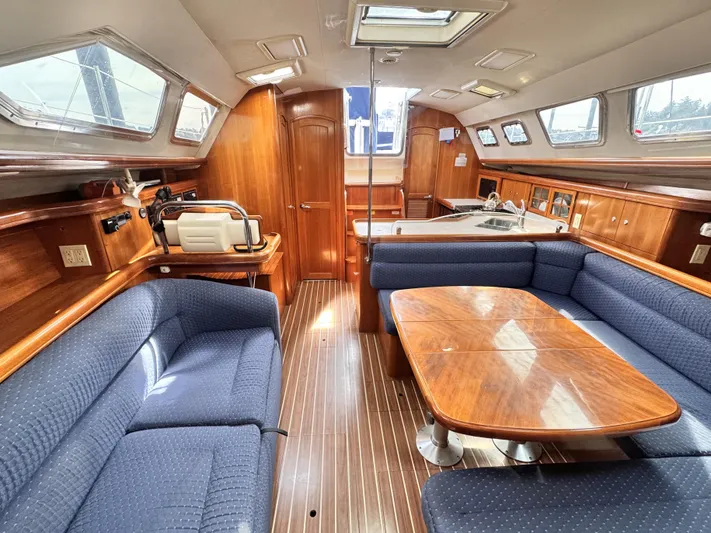 Stormcat Yacht Photos Pics Luxurious interior of 2006 Hunter 41 Deck Salon with wood finish and blue seating.