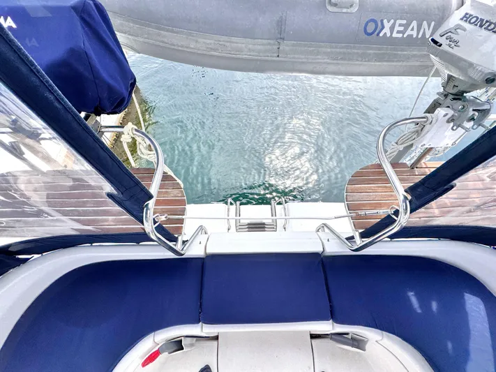 Stormcat Yacht Photos Pics 2006 Hunter 41 Deck Salon yacht stern view with blue seating and water backdrop.