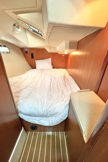 Stormcat Yacht Photos Pics Cozy cabin interior of 2006 Hunter 41 Deck Salon with wooden finish and comfortable bedding.
