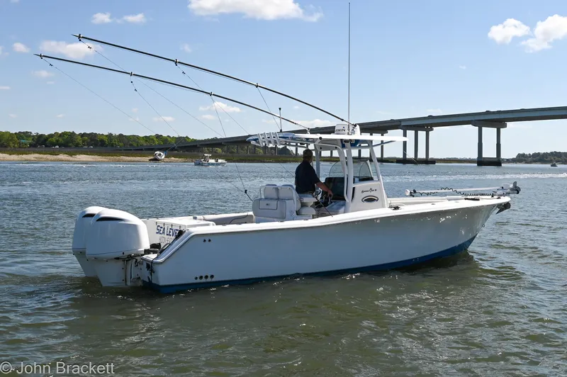Sea Level Yacht Photos Pics 2014 Sea Hunt Gamefish 30 boat on water near a bridge, with fishing rods visible.