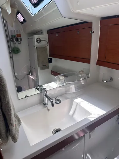  Yacht Photos Pics Beneteau Oceanis 50 bathroom interior, featuring a sleek sink and wooden cabinetry, 2014 model.