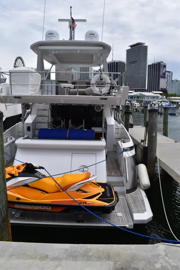  Yacht Photos Pics 2018 Azimut Flybridge yacht docked with orange jet ski, city skyline in background.