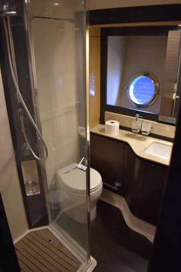  Yacht Photos Pics 2018 Azimut Flybridge yacht bathroom with shower, toilet, sink, and porthole window.