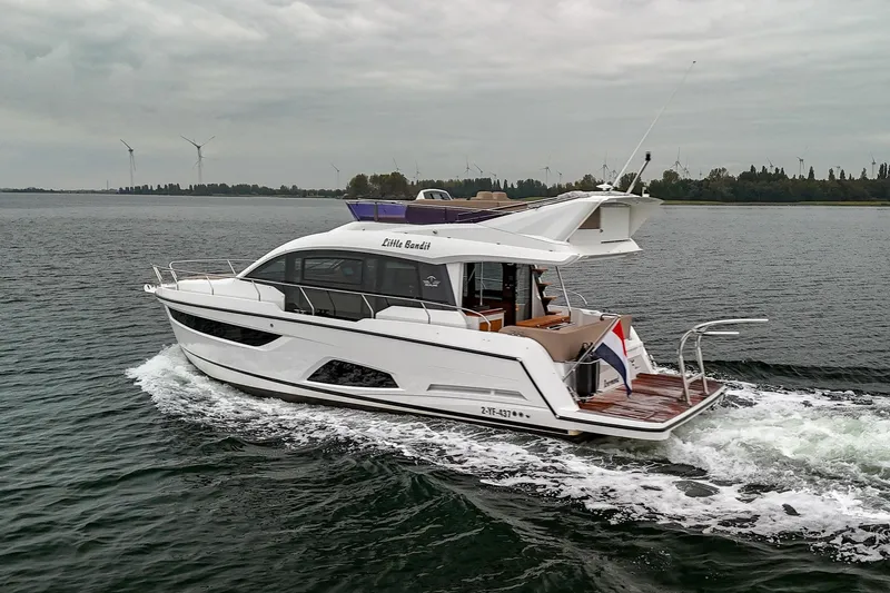  Yacht Photos Pics 2021 Sealine F430 yacht cruising on a calm waterway under cloudy skies.