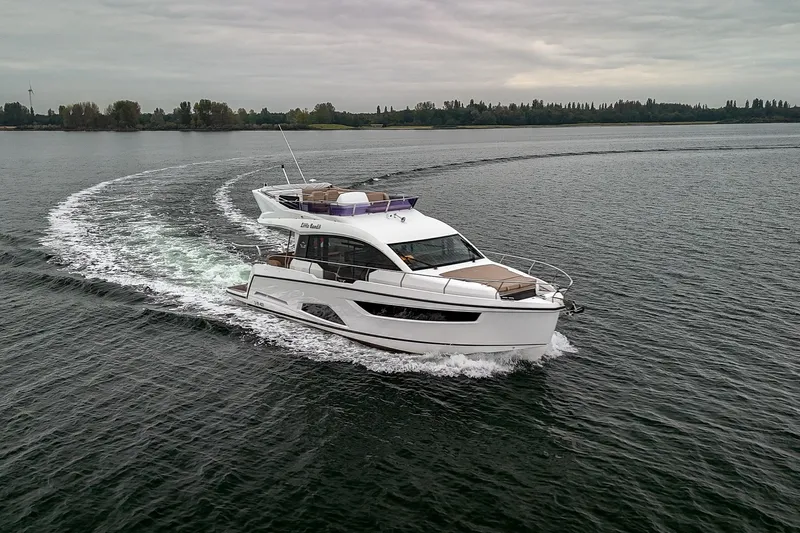  Yacht Photos Pics 2021 Sealine F430 yacht cruising on a calm lake under cloudy skies.