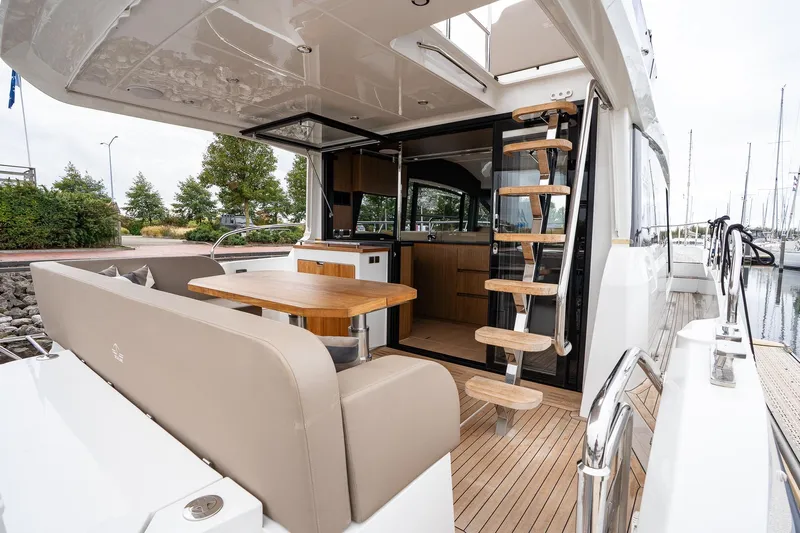  Yacht Photos Pics 2021 Sealine F430 yacht interior with dining area and wooden staircase.