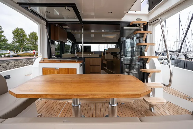  Yacht Photos Pics Luxurious 2021 Sealine F430 yacht interior with wooden table and spiral staircase.