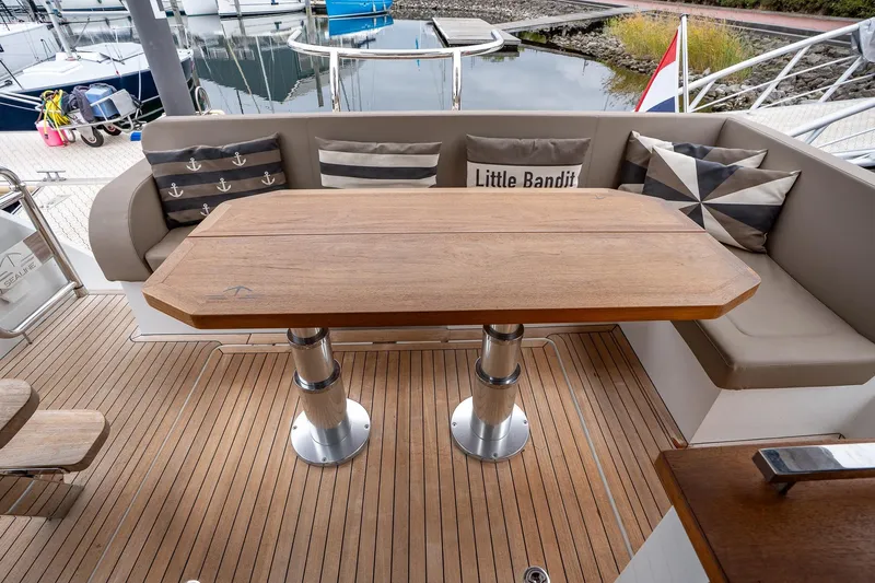  Yacht Photos Pics 2021 Sealine F430 yacht deck with wooden table and cushioned seating.