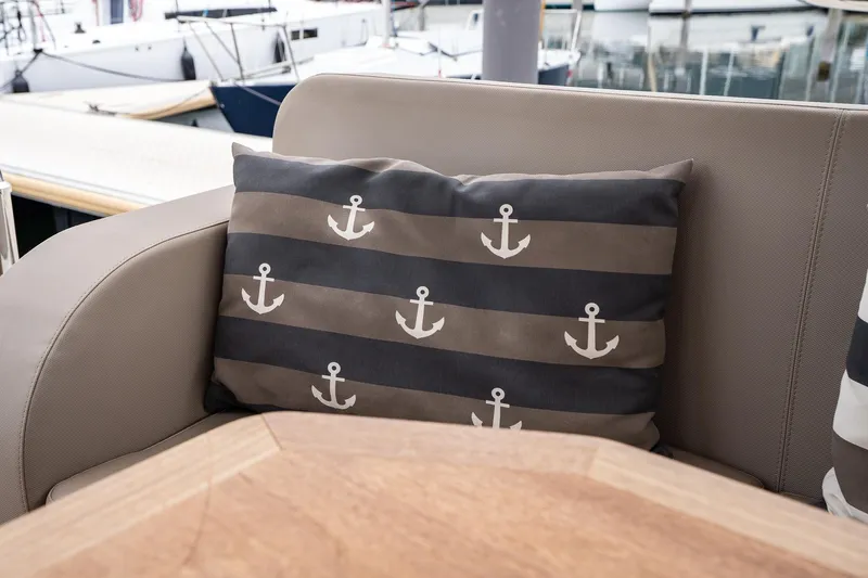  Yacht Photos Pics Cushioned seating on 2021 Sealine F430 yacht with anchor-patterned pillow, docked at marina.