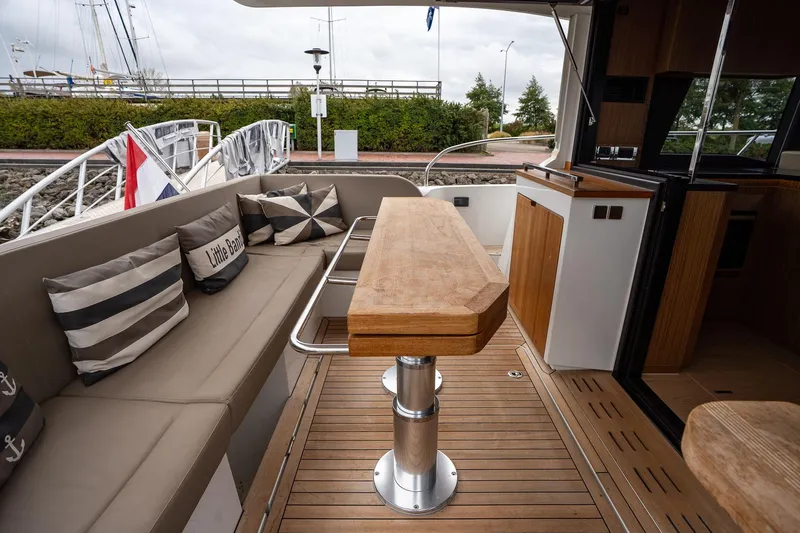  Yacht Photos Pics 2021 Sealine F430 yacht interior with wooden table, cushioned seating, and nautical decor.