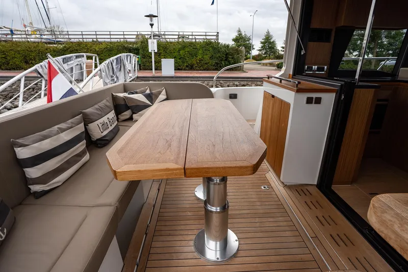  Yacht Photos Pics Luxurious 2021 Sealine F430 yacht deck with wooden table and cushioned seating.