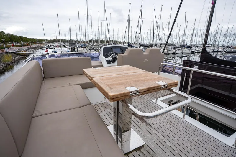  Yacht Photos Pics Luxurious 2021 Sealine F430 yacht with spacious deck seating and wooden table in marina.