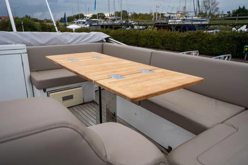  Yacht Photos Pics Luxurious seating area on 2021 Sealine F430 yacht with wooden table and cushioned benches.