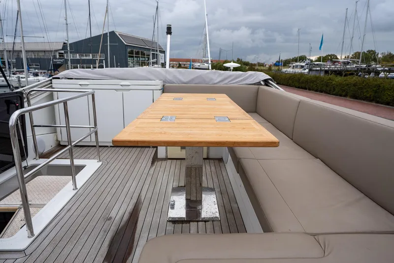  Yacht Photos Pics Sealine F430 2021 yacht deck with wooden table and cushioned seating in marina.