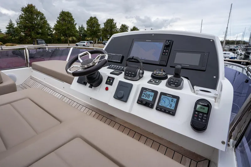  Yacht Photos Pics Control panel of 2021 Sealine F430 yacht with navigation instruments and steering wheel.
