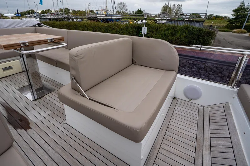  Yacht Photos Pics 2021 Sealine F430 yacht deck with cushioned seating and wooden table.