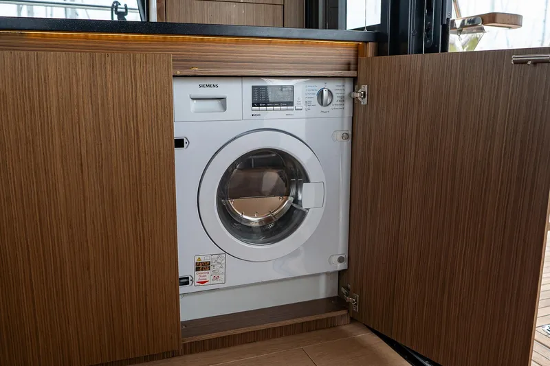  Yacht Photos Pics Built-in Siemens washing machine in 2021 Sealine F430 yacht's wooden cabinet.