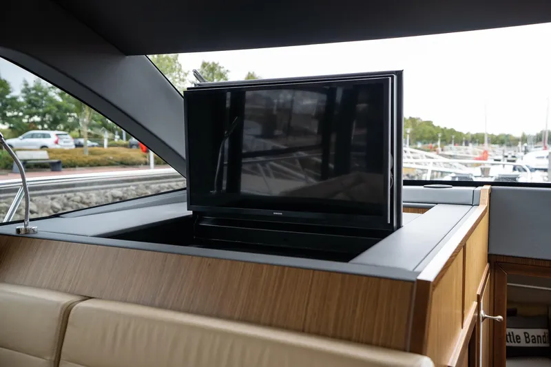  Yacht Photos Pics 2021 Sealine F430 yacht interior with retractable TV in wooden cabinet.
