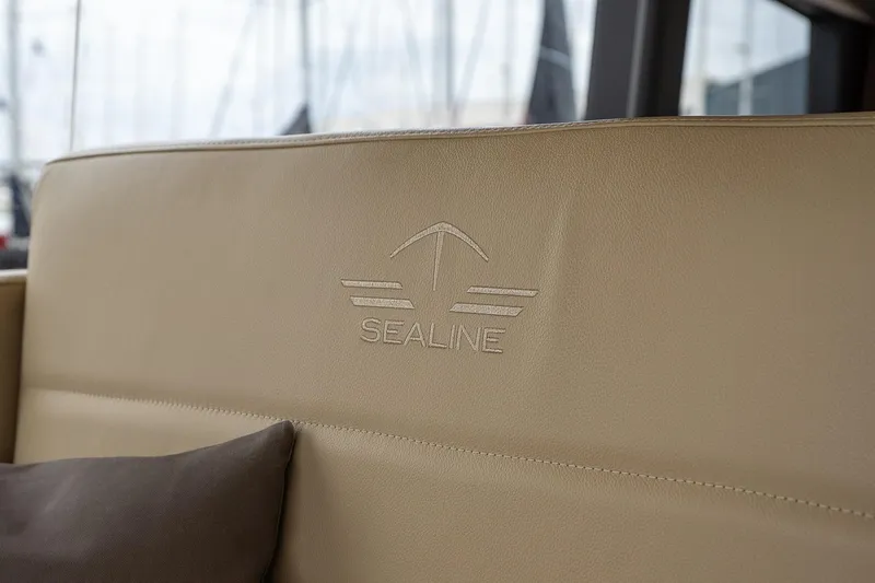  Yacht Photos Pics Sealine F430 2021 yacht interior with embossed logo on beige leather seating.