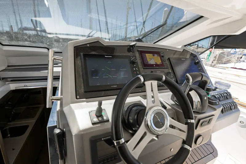 Loki Yacht Photos Pics Control panel of 2018 Azimut Verve 40 yacht with steering wheel and navigation screens.