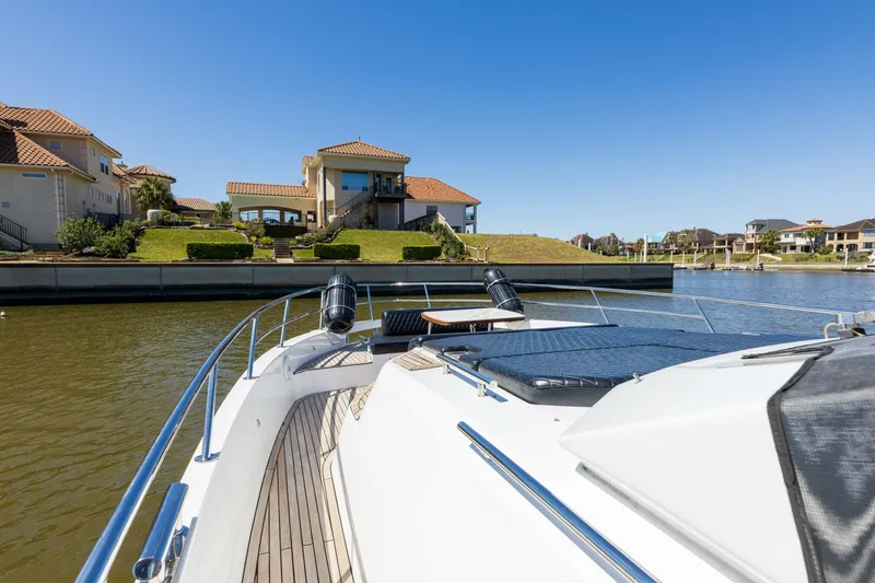 Loki Yacht Photos Pics 2018 Azimut Verve 40 yacht cruising near waterfront homes under clear blue sky.