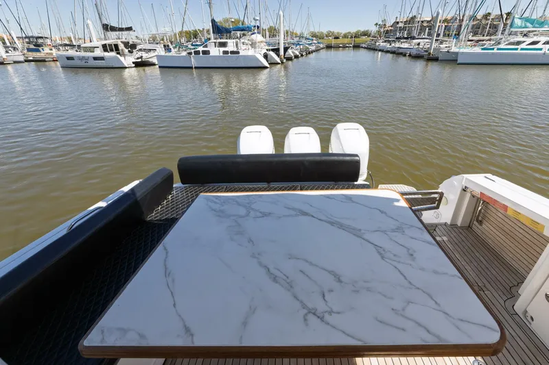 Loki Yacht Photos Pics 2018 Azimut Verve 40 yacht with marble table, docked in a marina with sailboats.