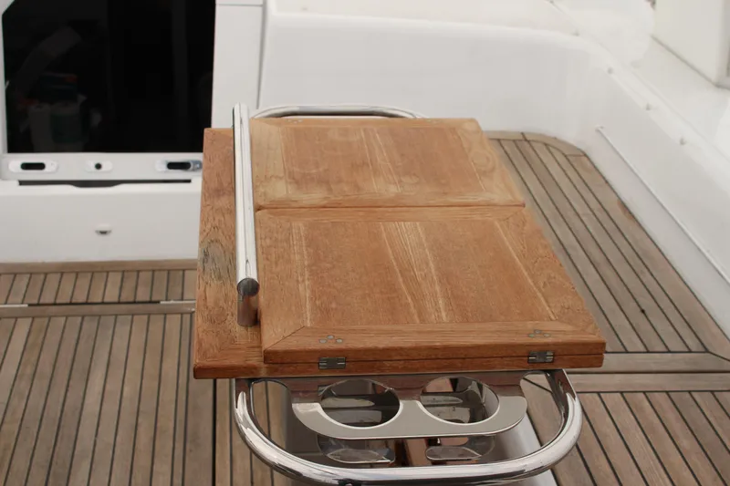 Spellbound Yacht Photos Pics Teak cockpit table on 2022 Beneteau Oceanis Yacht 54, featuring integrated cup holders.