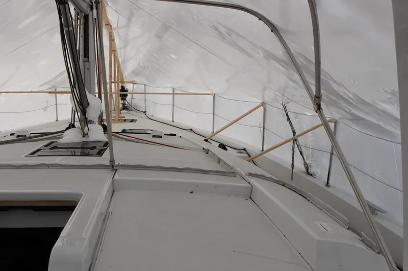 Spellbound Yacht Photos Pics Looking port and forward: Beneteau Oceanis Yacht 54, 2022 model, covered in snow under protective shelter.