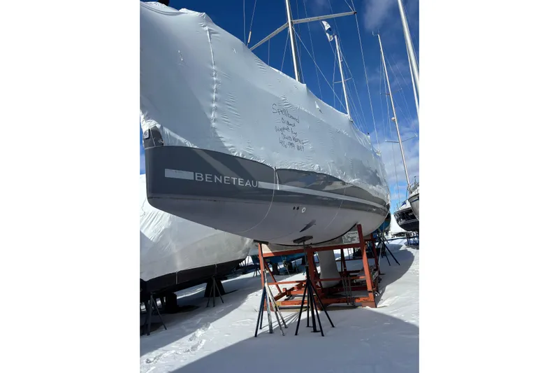 Spellbound Yacht Photos Pics 2022 Beneteau Oceanis Yacht 54 covered in protective wrap, stored on stands in snowy setting.