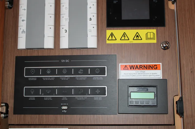 Spellbound Yacht Photos Pics Control panel of 2022 Beneteau Oceanis Yacht 54 with warning labels and switches.