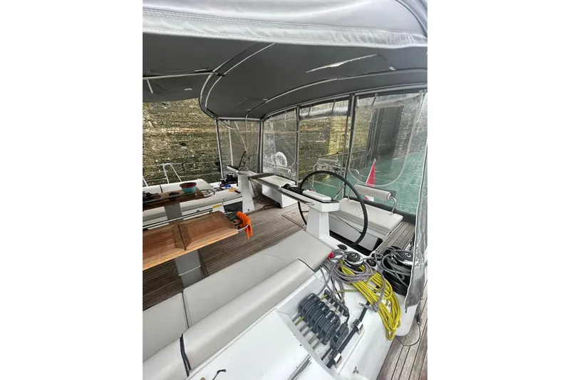 Spellbound Yacht Photos Pics 2022 Beneteau Oceanis Yacht 54 cockpit with steering wheel and seating area.