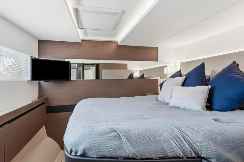 Closer To The Sun Yacht Photos Pics Luxurious bedroom interior of 2025 Leopard 53 Powercat yacht with modern design and cozy bedding.