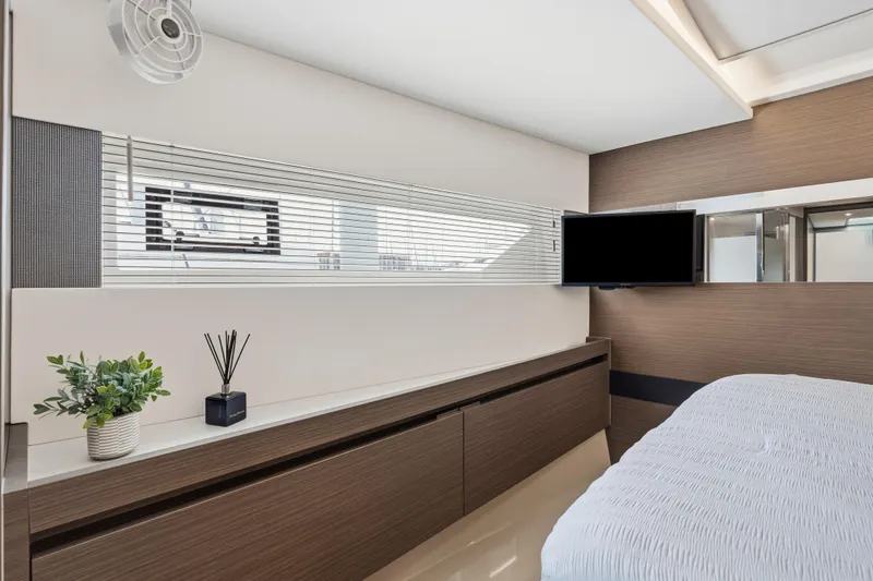 Closer To The Sun Yacht Photos Pics Luxurious interior of 2025 Leopard 53 Powercat yacht bedroom with modern decor and TV.