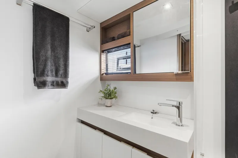 Closer To The Sun Yacht Photos Pics Modern bathroom in 2025 Leopard 53 Powercat yacht with sleek sink and wooden accents.