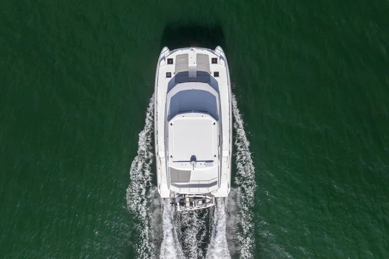 Closer To The Sun Yacht Photos Pics Aerial view of 2025 Leopard 53 Powercat cruising on green water.