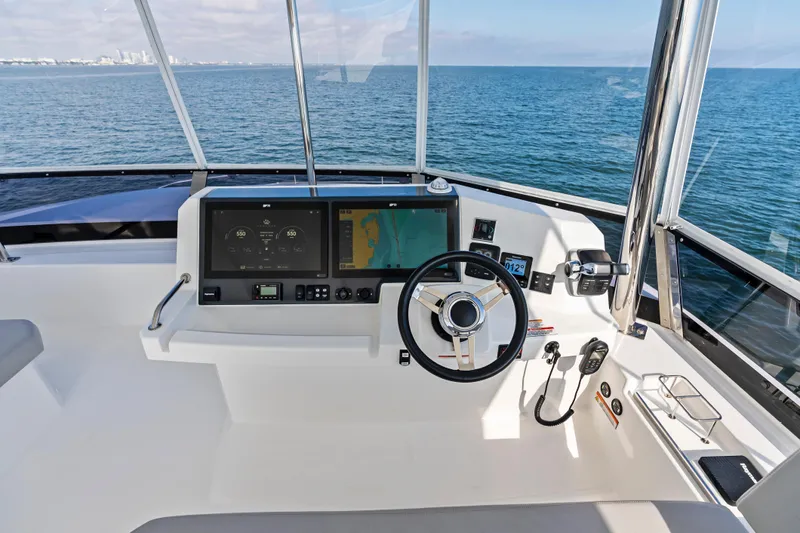 Closer To The Sun Yacht Photos Pics Helm of 2025 Leopard 53 Powercat with modern navigation systems, steering wheel, and ocean view.