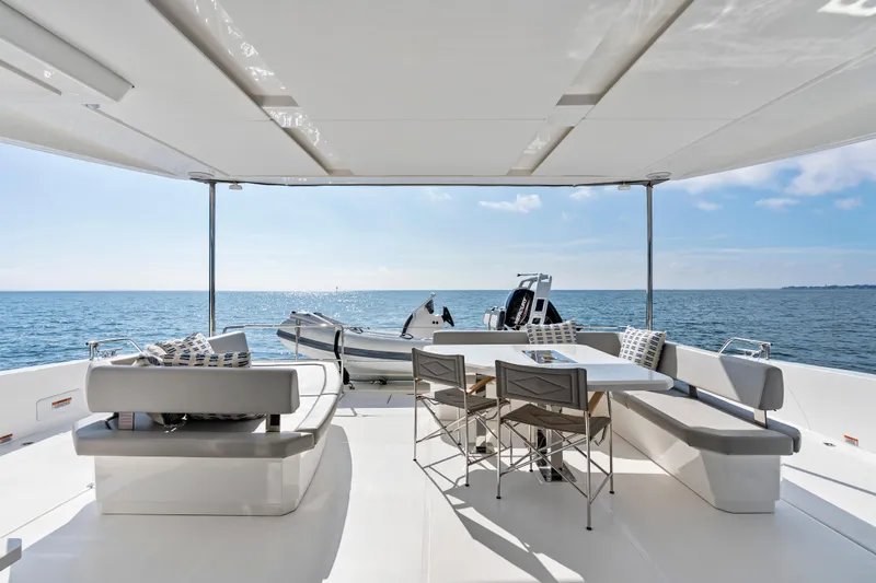 Closer To The Sun Yacht Photos Pics 2025 Leopard 53 Powercat yacht deck with seating, table, and ocean view.