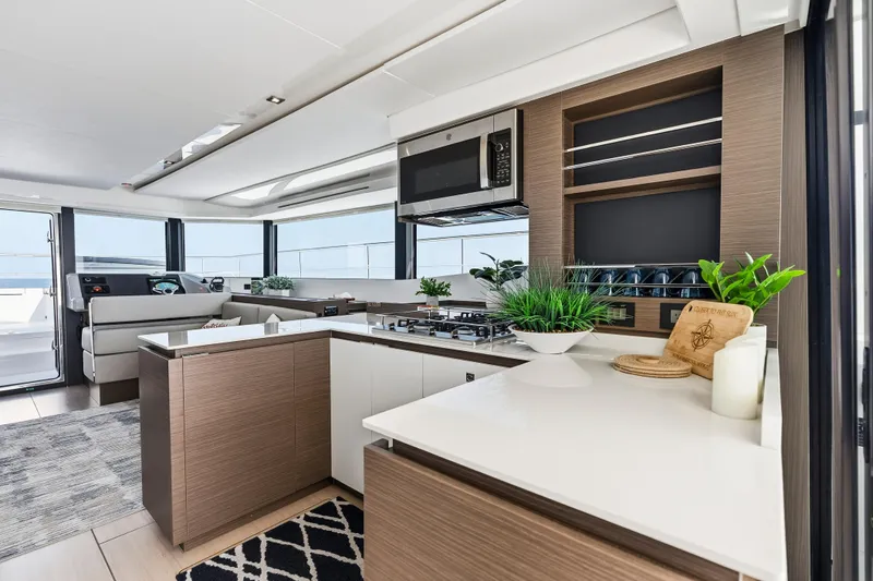 Closer To The Sun Yacht Photos Pics Luxurious interior of 2025 Leopard 53 Powercat yacht with modern kitchen and panoramic windows.