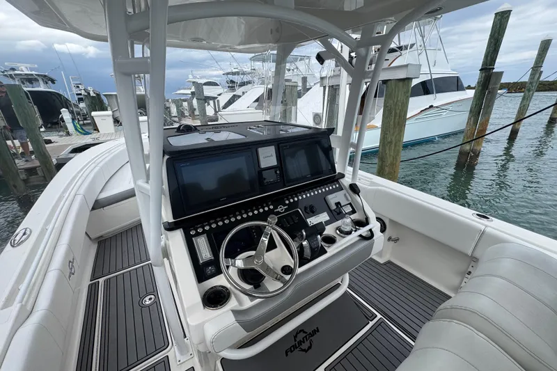  Yacht Photos Pics 2018 Fountain 34 Center Console boat interior with advanced navigation system at marina.